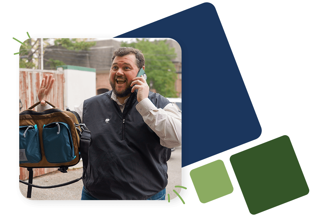 Happy businessman waves while talking on a cellphone